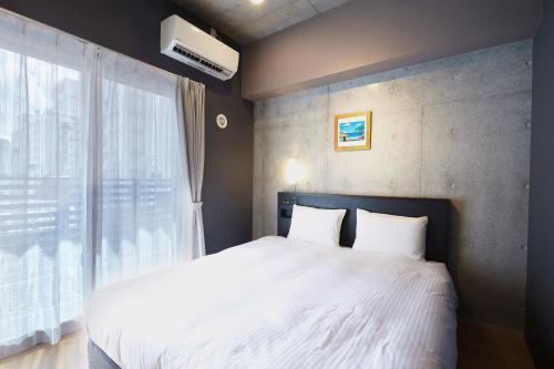 Postel nebo postele na pokoji v ubytování NAHA-WEST INN