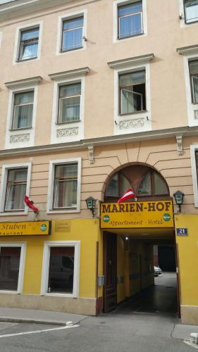 a yellow building with a marian hotel sign on it at Appartement Hotel Marien-Hof in Vienna