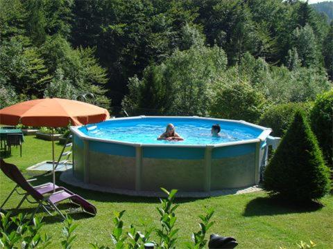 two people in a hot tub in a yard at Landhaus Teufl in Faistenau