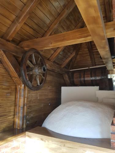 a room with a wooden ceiling with a wheel at Casa de Oaspeti la Bilbor in Bilbor