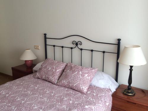 a bed with a purple comforter and two lamps at Living Gijon & Parking in Gijón