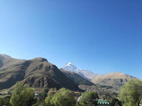 a view of a town in a valley with mountains at Guest House on V. Pshavela 50 in Stepantsminda