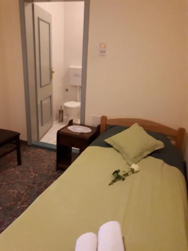 a bedroom with a bed with a flower on it at Business Club Selenča in Bač