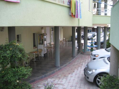 a building with cars parked on the side of a sidewalk at Guest House Vila Mimoza in Ulcinj