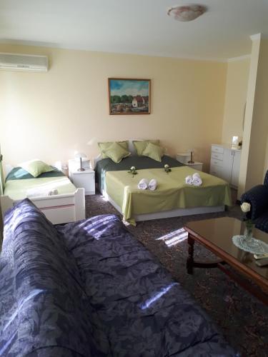 a bedroom with two beds and a coffee table at Business Club Selenča in Bač