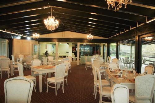 a dining room with tables and chairs and chandeliers at Hotel ToacaBellevue in Gura Humorului