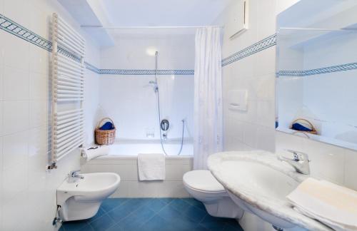 a bathroom with a sink and a toilet and a shower at Hotel & Appartements Perwanger in Völs am Schlern