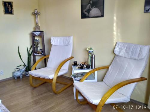 two white chairs in a room with a table at Homestay Poděbrady in Poděbrady