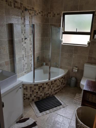 un bagno con vasca, WC e lavandino di Stukkie Cottage a Hermanus
