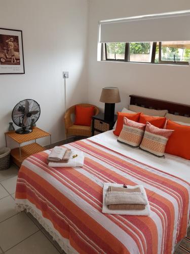 a bedroom with a large bed with towels on it at Stukkie Cottage in Hermanus