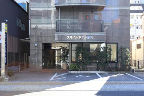 a building with a balcony on the side of it at Smile Hotel Shizuoka in Shizuoka