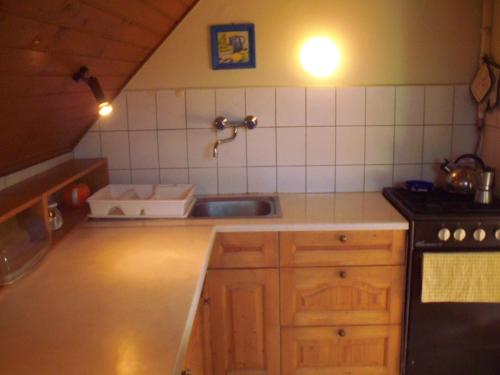 a small kitchen with a sink and a stove at Topáz Vendégház in Sopron