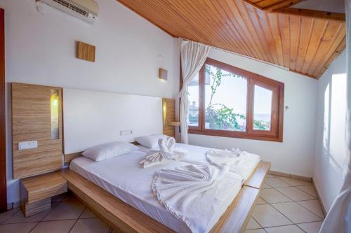 1 dormitorio con 1 cama grande y techo de madera en Villa Sonata, en Alanya