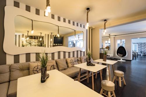 a living room with a couch and tables and a mirror at Retro Design Hotel in Langeoog