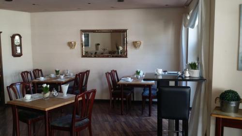 a dining room with tables and chairs and a mirror at Hotel am Stadion in Duisburg