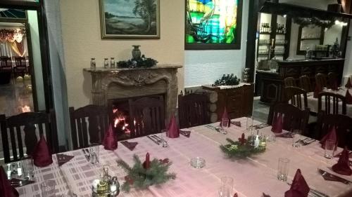 a dining room with a table with a fireplace at Business Club Selenča in Bač