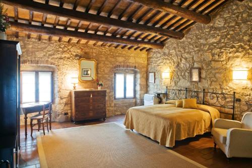 - une chambre avec un lit et un mur en pierre dans l'établissement I Costanti, à Caldiero