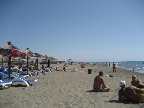 a group of people sitting on the beach at Guest House Vila Mimoza in Ulcinj