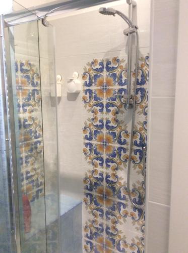 a shower with a blue and white pattern on the wall at B&B Cuore di Salerno in Salerno
