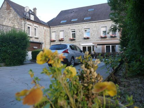 a car parked in front of a building with yellow flowers at Hotel Val Saint Hilaire in Givet