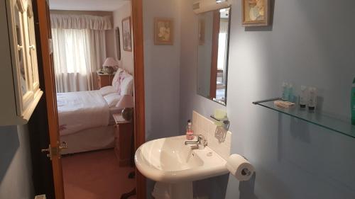 a bathroom with a sink and a bedroom with a bed at Hosefield Bed and Breakfast in Ellon