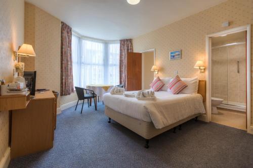 a hotel room with a large bed and a bathroom at Eliot Hotel in Newquay