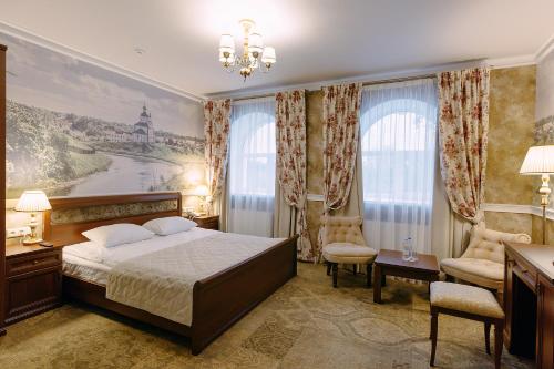 a bedroom with a bed and a desk and chairs at Kremlyovskiy Park in Ryazan