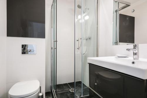 une salle de bain blanche avec un lavabo et une douche dans l'établissement La Canourgue, Appart de charme ,Parking gratuit, à Montpellier