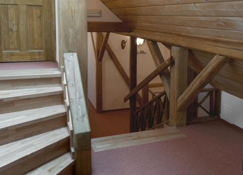 an attic with wooden stairs in a room at Wellness Hotel Holzberg in Suchá Rudná