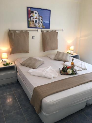 a large white bed with a tray of food on it at Maistrali Studios in Batsi