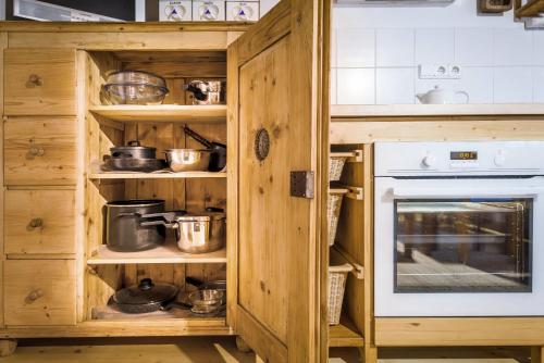 a kitchen with wooden cabinets with pots and pans at Drevenica Traditional Cottage Old Centre in Zuberec