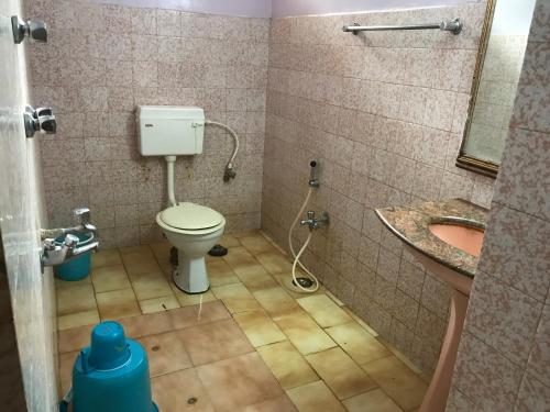 a bathroom with a toilet and a sink at Campal Beach Resort in Panaji