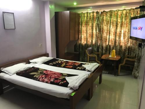 a bedroom with a bed and a tv in a room at Campal Beach Resort in Panaji