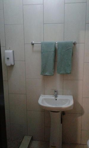 a bathroom with a sink and blue towels at Central Lodge Hotels in Johannesburg