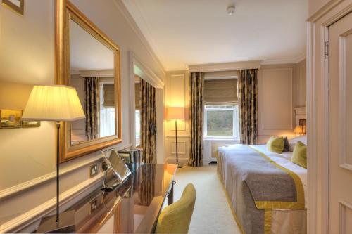 a hotel room with a bed and a mirror at Isle of Eriska Hotel Spa & Island in Benderloch