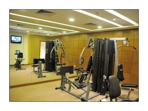 a gym with several tread machines in a room at Adarsh Hamilton in Bengaluru