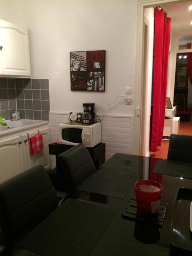 a kitchen with a table and a microwave in a room at Chambres dans guest house Centre ville in Menton