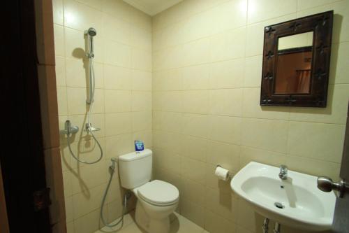 a bathroom with a shower and a toilet and a sink at Duana's Homestay in Ubud