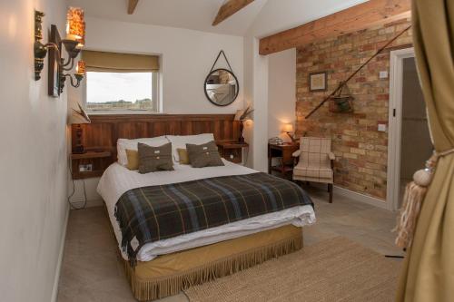 a bedroom with a bed and a brick wall at Bridleway Bed & Breakfast in Lincoln