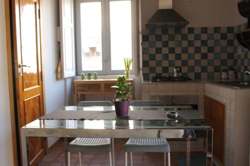 uma cozinha com uma mesa e cadeiras numa cozinha em Appartamento in centro em Catânia