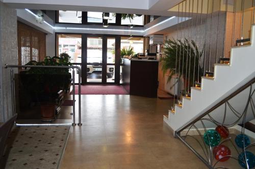 a lobby with stairs and potted plants at Hotel Premier in Sibiu