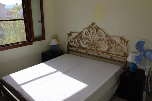 ブドーニにあるCasa Vancanze Budoniのベッドルーム1室(ベッド1台、窓、ファン付)が備わります。