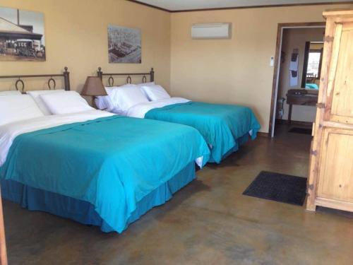 two beds in a room with blue and white sheets at HH Creek Inn in Seymour