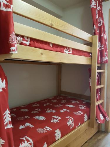 - un lit superposé avec une couverture rouge sur le lit inférieur dans l'établissement Studio d'Anaite, aux Houches