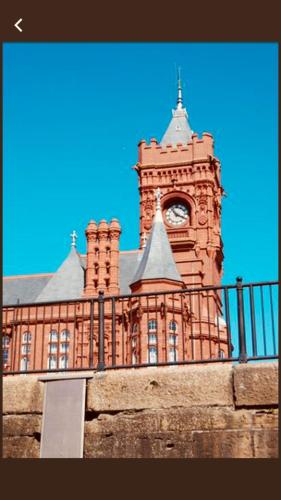 a large brick building with a clock tower at Sky Night Serviced Apartments in Cardiff