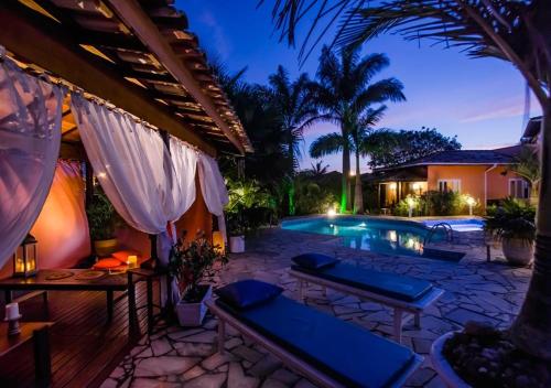 a resort with a swimming pool at night at Villa Baobá in Búzios