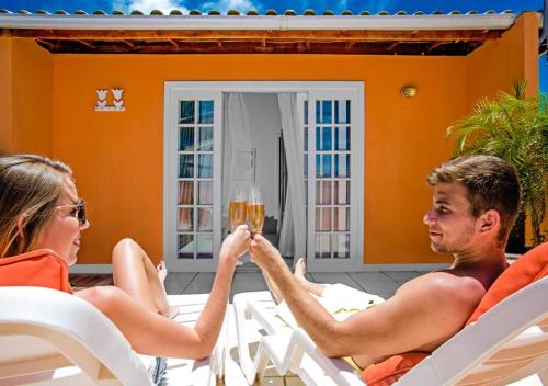 a man and woman sitting at a table with a glass of wine at Villa Baobá Pousada & Spa in Búzios