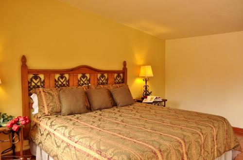 um quarto com uma cama e uma parede amarela em Horsepower Ranch em Ensenada