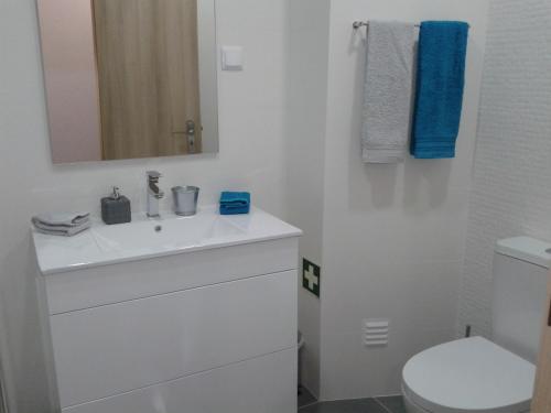 une salle de bains avec un lavabo blanc et des toilettes dans l'établissement Gui Beach House, à Armação de Pêra
