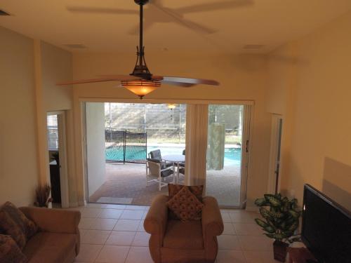 a living room with a couch and a ceiling fan at Formosa Garden Pool Home in Orlando